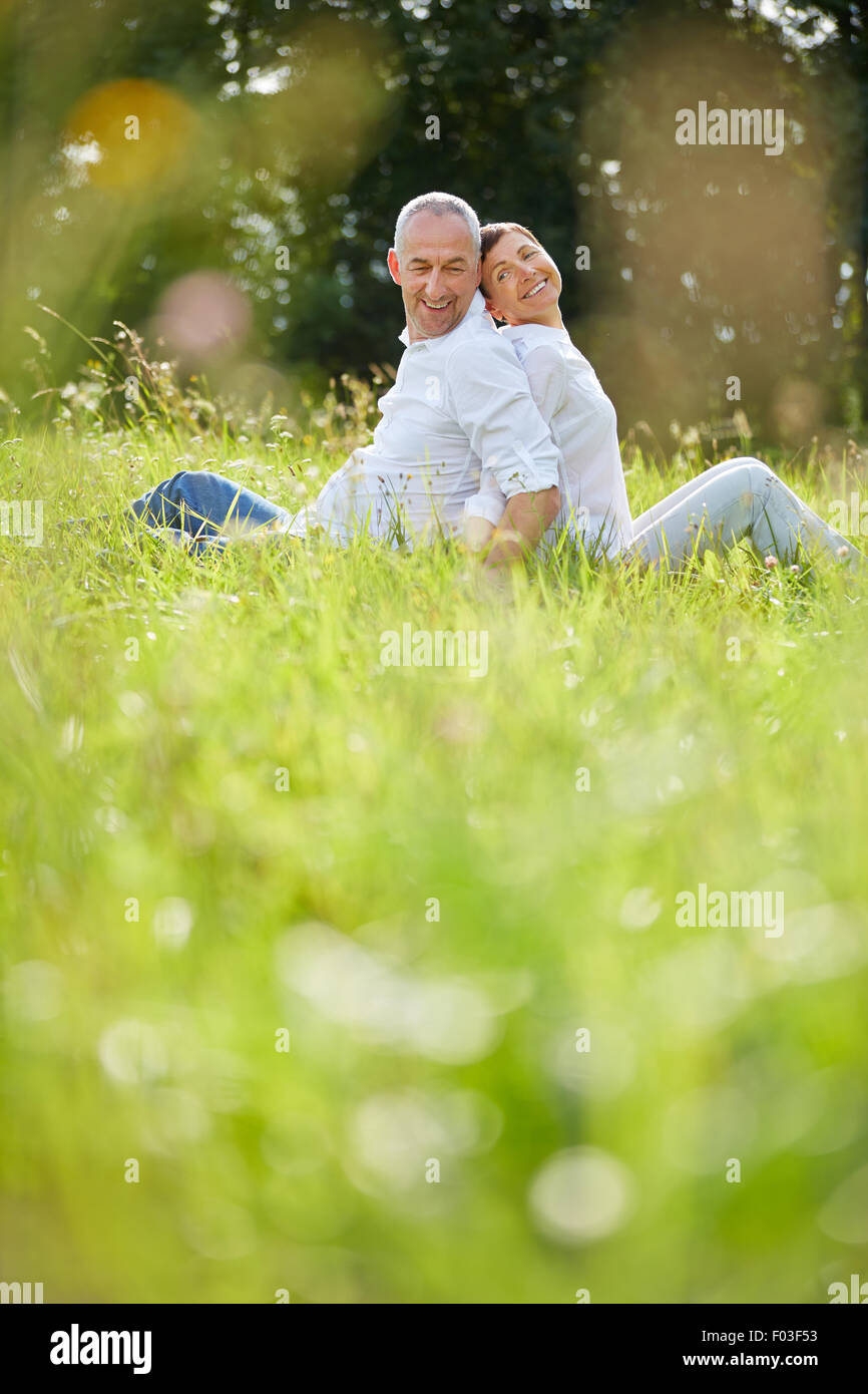 Gerne älteres paar sitzen in Rasen im Sommer in der Natur Stockfoto