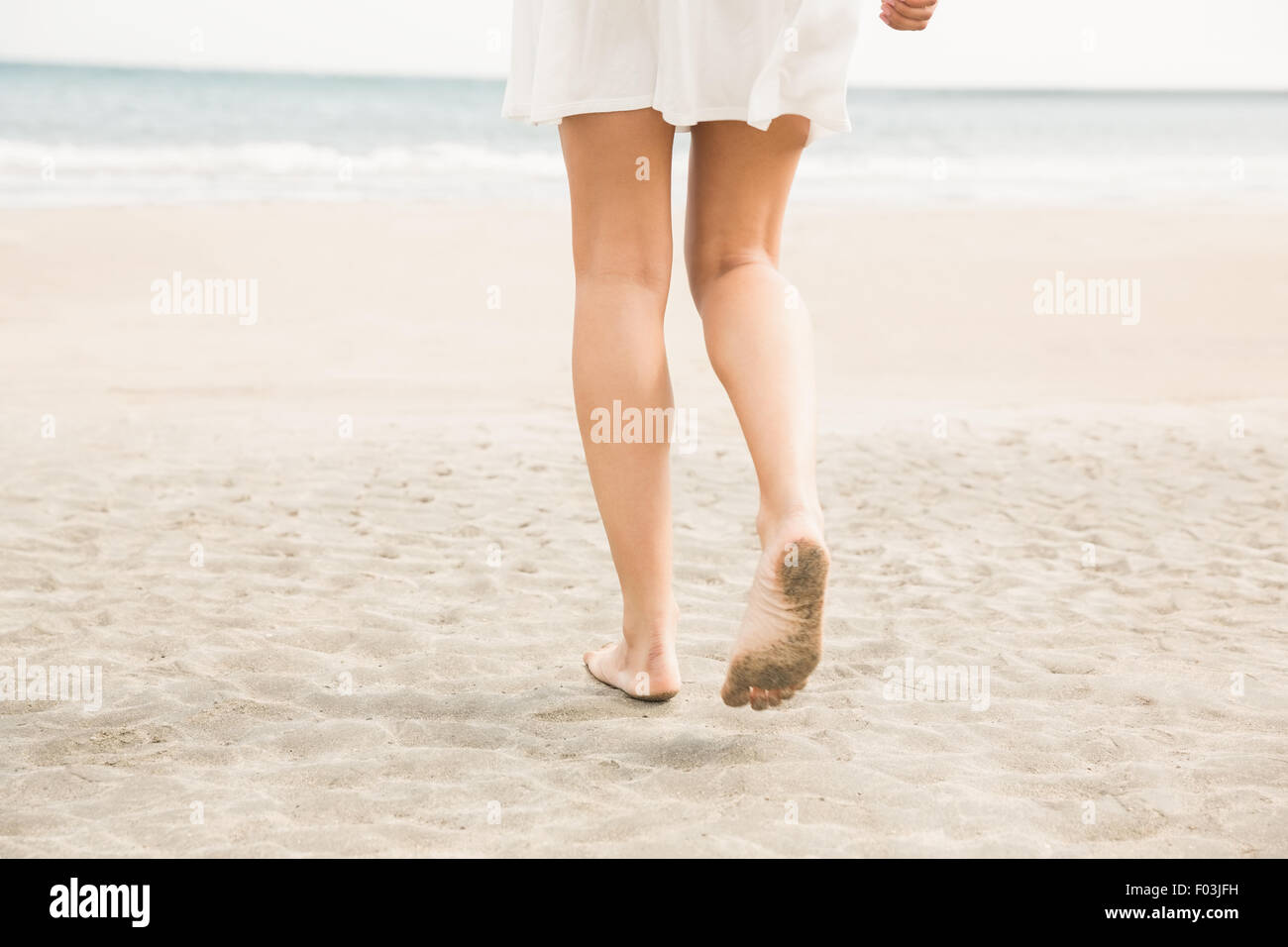 Stilvolle Frau zu Fuß auf den sand Stockfoto