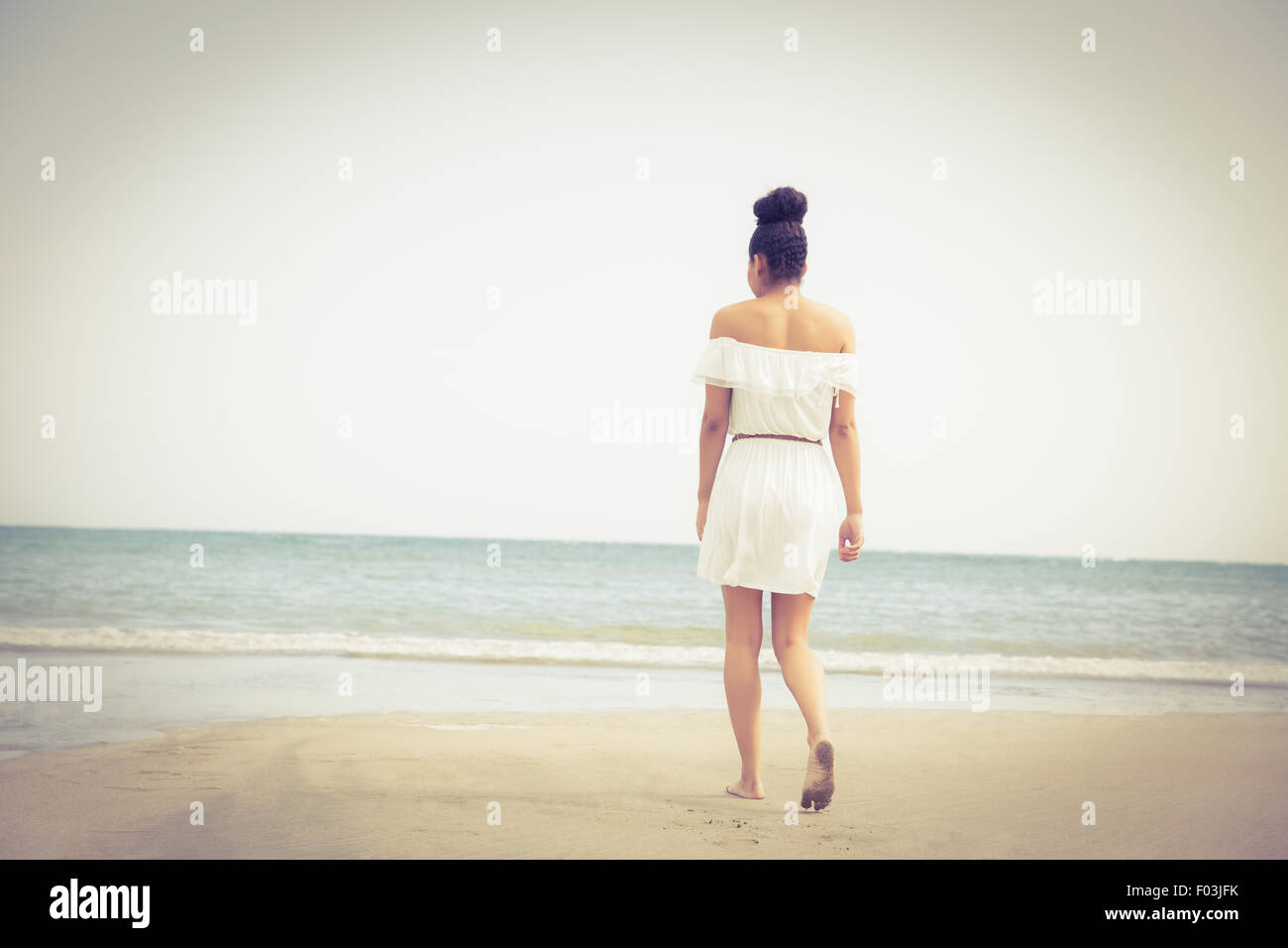 Stilvolle Frau zu Fuß auf den sand Stockfoto