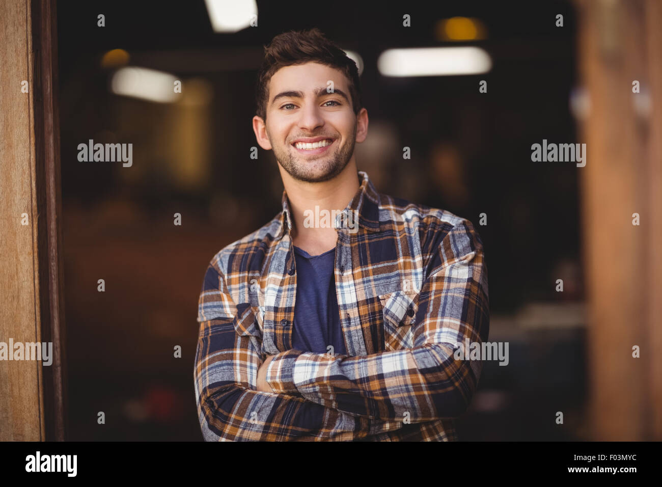 Lächelnd lässige Kellner mit Arme gekreuzt Stockfoto