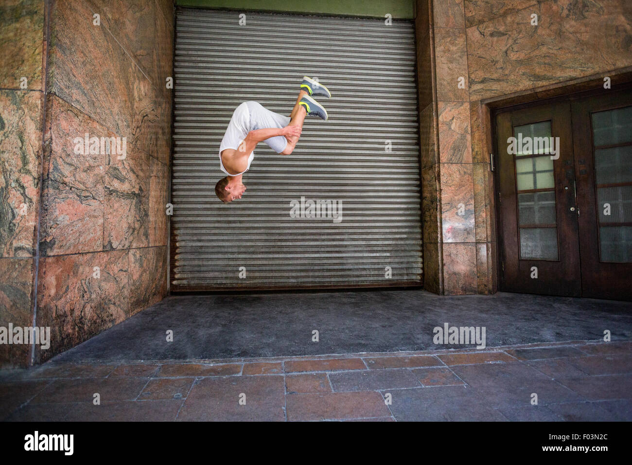 Extremsportler dabei einen Frontflip vor einem Gebäude Stockfoto