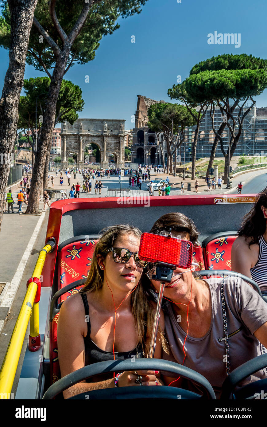 Passagiere auf offenen gekrönt Tour-Bus nehmen ein Selbstporträt mit einem Handy auf ein Selfie-Stick. Stockfoto