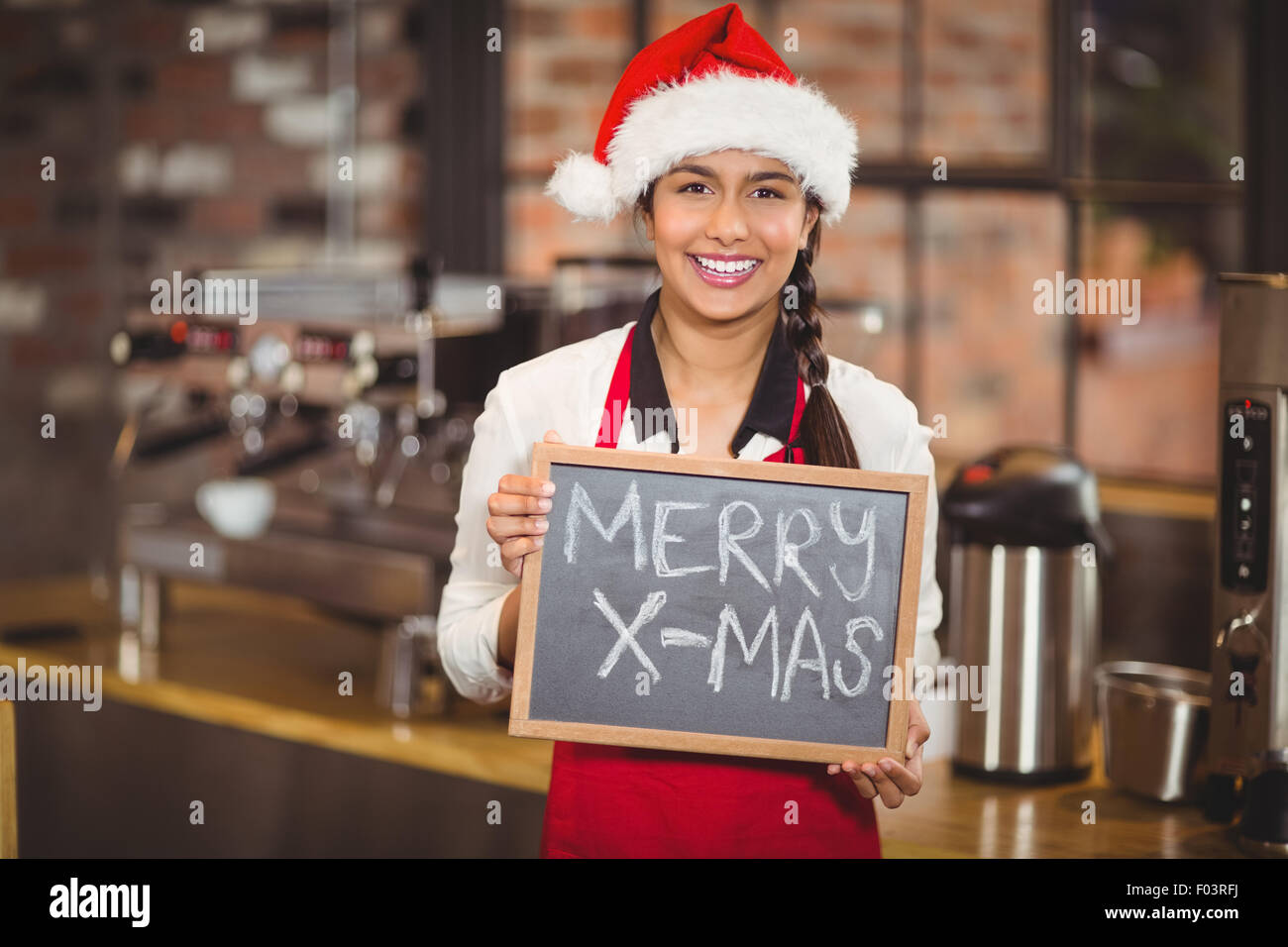 Hübsche Kellnerin mit einer Tafel Frohe Weihnachten Stockfoto