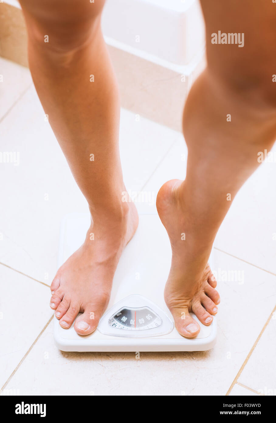 Frau wiegen sich barfuß auf Waage Stockfoto