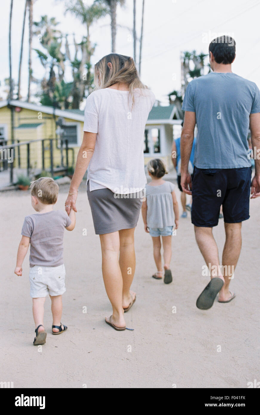 Heckansicht des eine Familie, ein paar gehen mit ihren kleinen Sohn und Tochter. Stockfoto