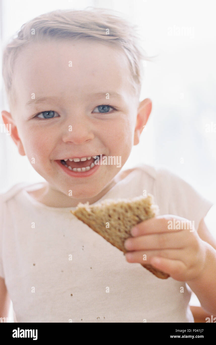 Porträt eines lächelnden jungen ein Sandwich zu essen. Stockfoto