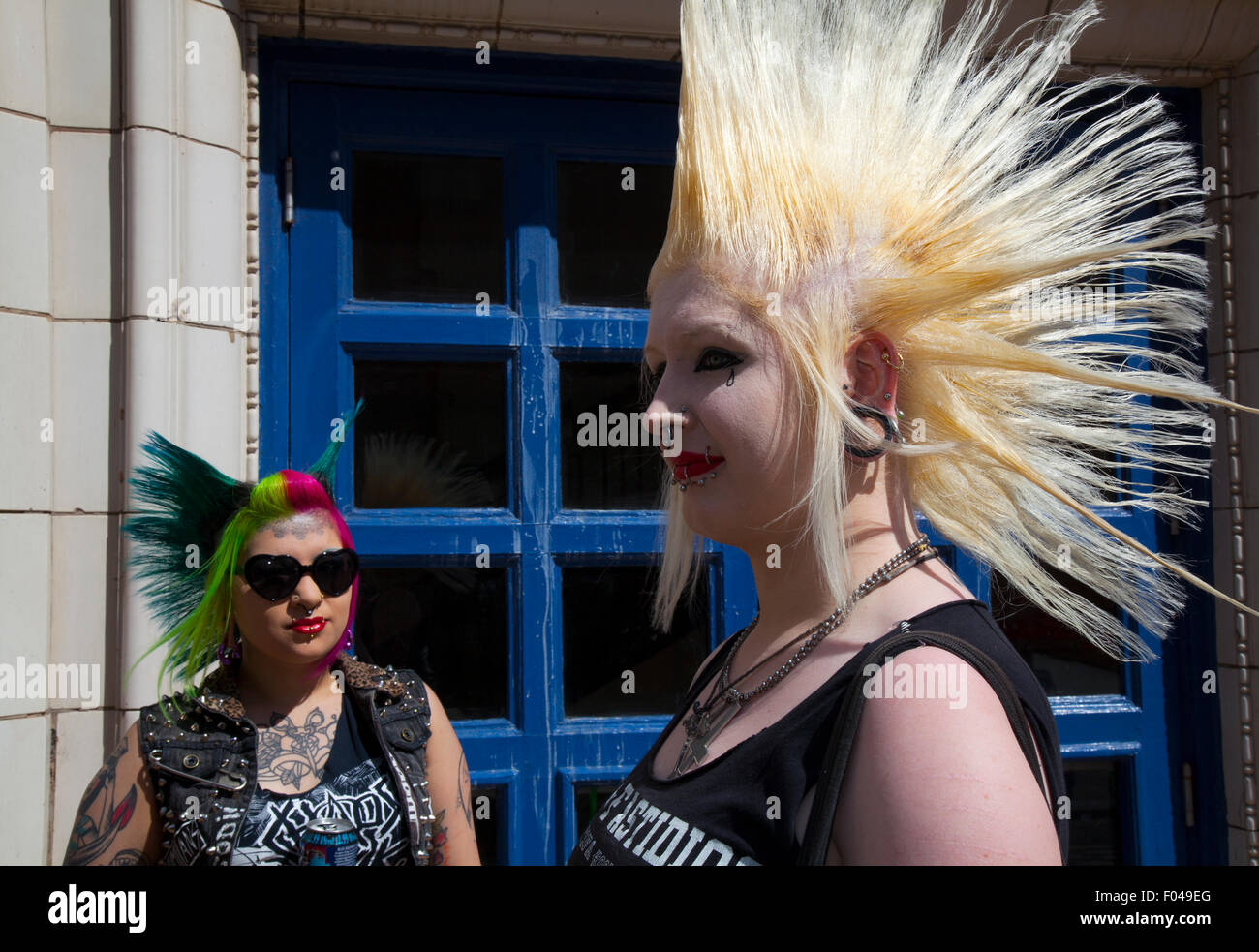 Punks mit mohican mohican Frisur gefärbte Freiheit bei Blackpool, Lancashire, UK. 7. Aug 2015. Punk Rebellion Paar, Festival im Winter Gardens. Ein Zusammenprall der Kulturen an der berühmten küstenstadt Blackpool als Punks, mit Liberty ährentragend Frisuren & Bolzen, Nieten, Nasenring, Mode, Frau, Haar, Haut. Frauen die Teilnahme an der jährlichen Rebellion Festival im Winter Gardens kommen Schulter mit traditionellen Urlauber zu schultern. Credit: MediaWorldImages/Alamy leben Nachrichten Stockfoto