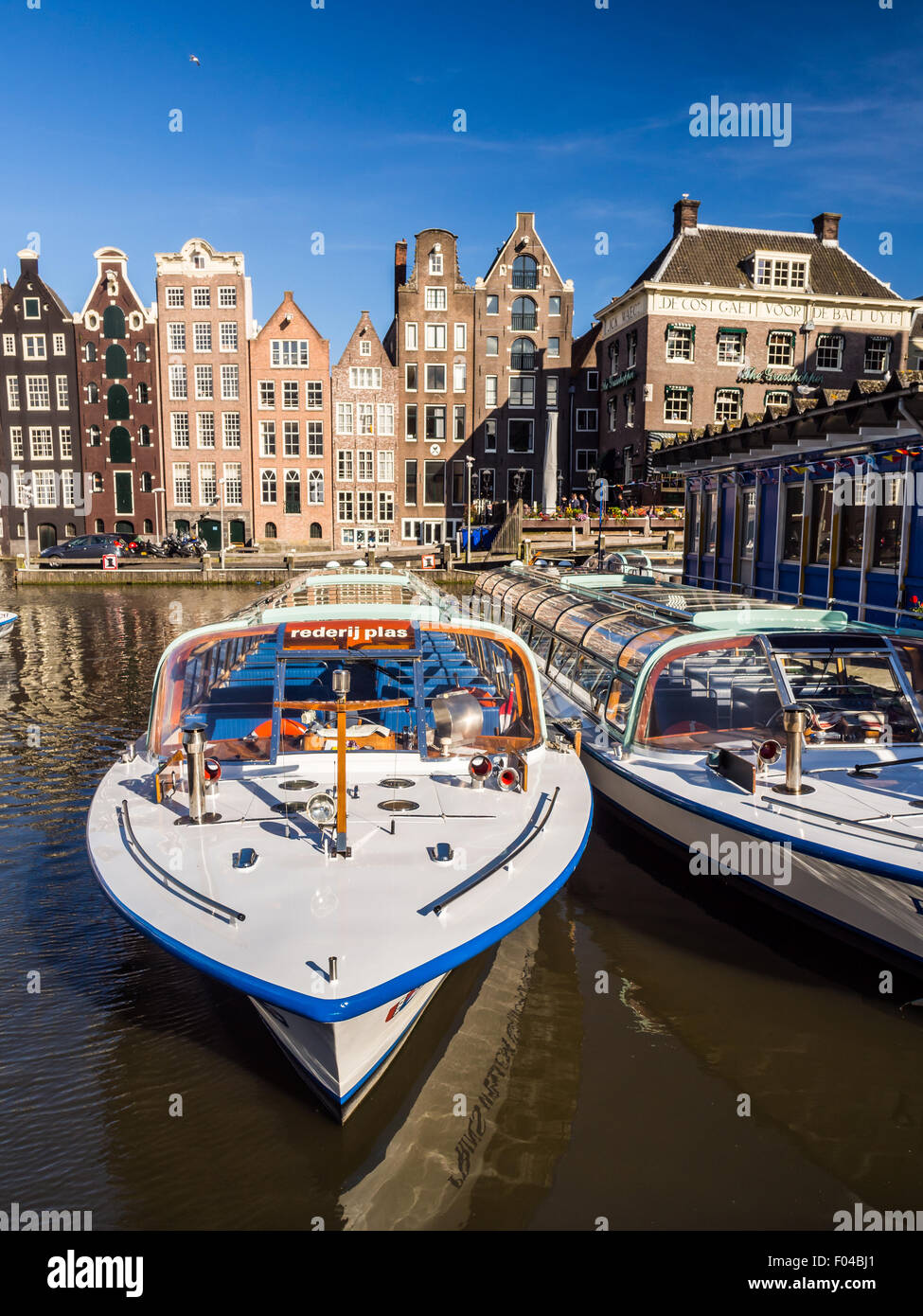 Kreuzfahrtschiff Touristen am Damrak Kanal in Amsterdam, Niederlande, an einem Sommertag. Traditionelle Häuser im Hintergrund. Stockfoto