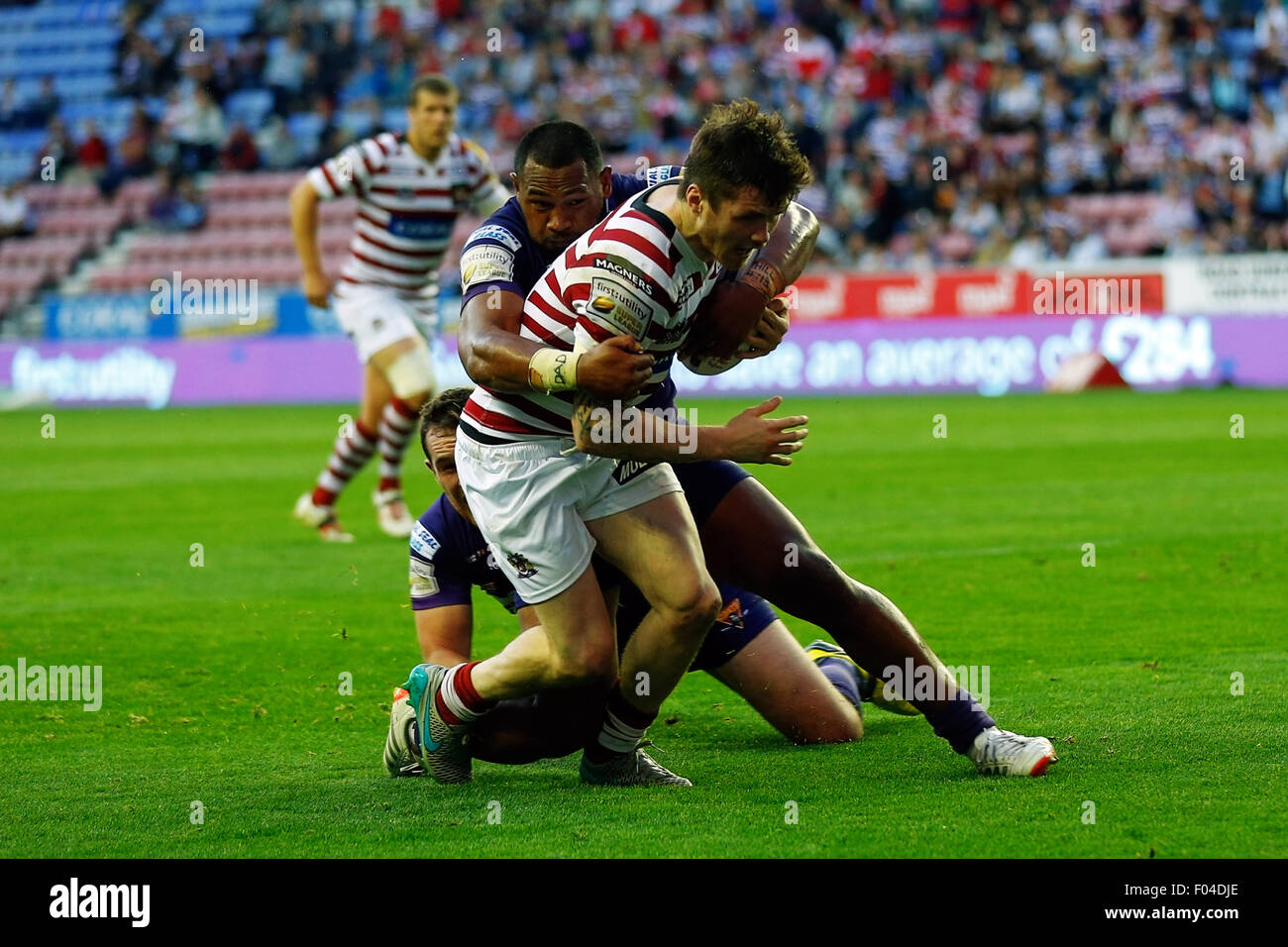 Wigan, England. 6. August 2015. Super League Super 8 s. Wigan Warriors gegen Huddersfield Riesen. John Bateman von Wigan Warriors von Jermaine McGillvary von Huddersfield Riesen Krediten gehalten wird: Action Plus Sport/Alamy Live News Stockfoto