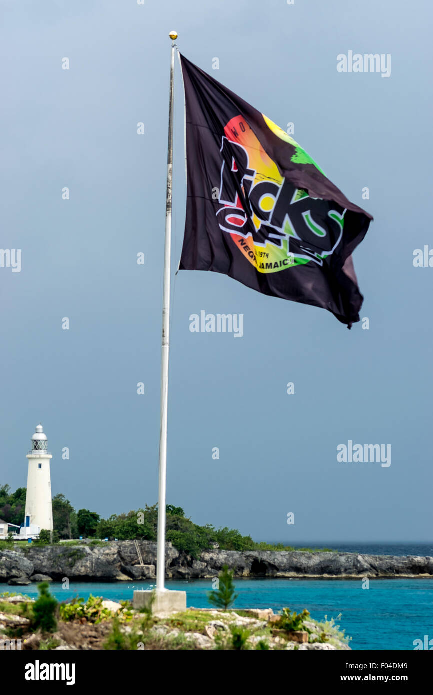 Negril, Jamaika - 30. Mai 2015: Ricks Cafe Flagge auf der Klippe und Negril Leuchtturm im Hintergrund. Stockfoto