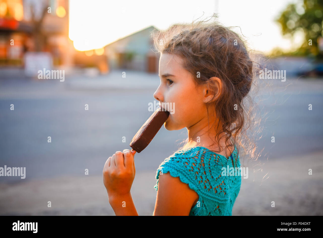 Mädchen, essen Eis außerhalb einer Seitenansicht Stockfoto