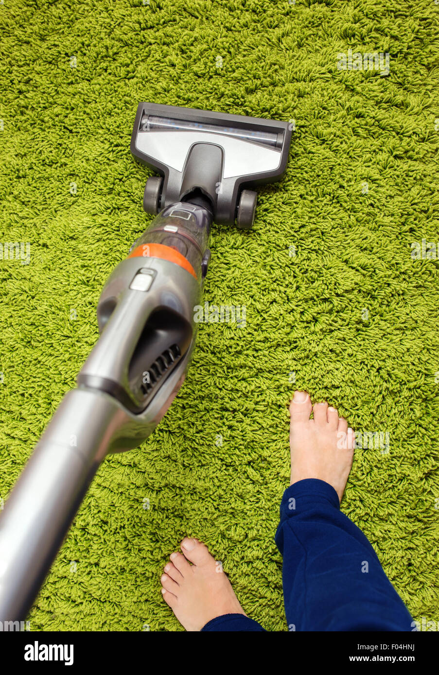 Staubsauger in Aktion - ein Männer sauberer Teppich Stockfoto