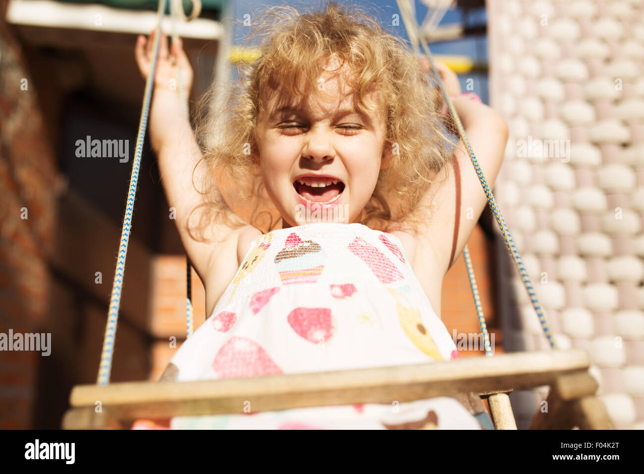 Glückliches Mädchen Spaß auf einer Schaukel an Sommertag Stockfoto