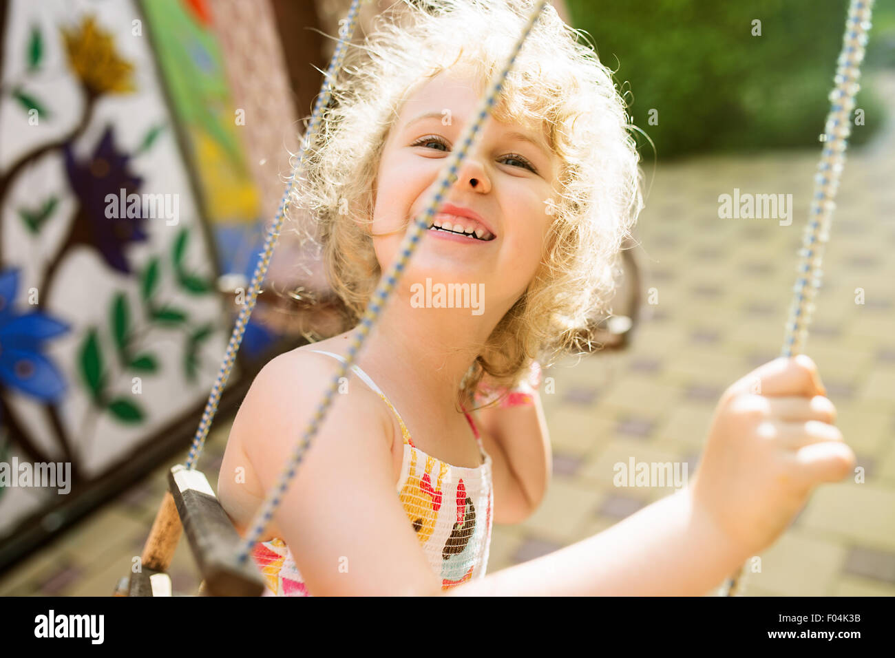 Glückliches Mädchen Spaß auf einer Schaukel an Sommertag Stockfoto