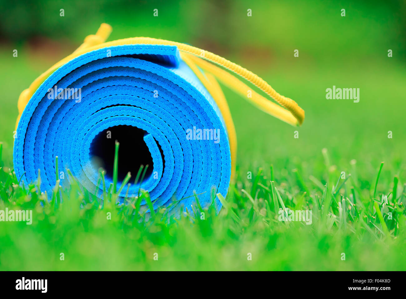 Blaue Yogamatte auf dem grünen Rasen, Nahaufnahme Foto, Fitness-Konzept Stockfoto