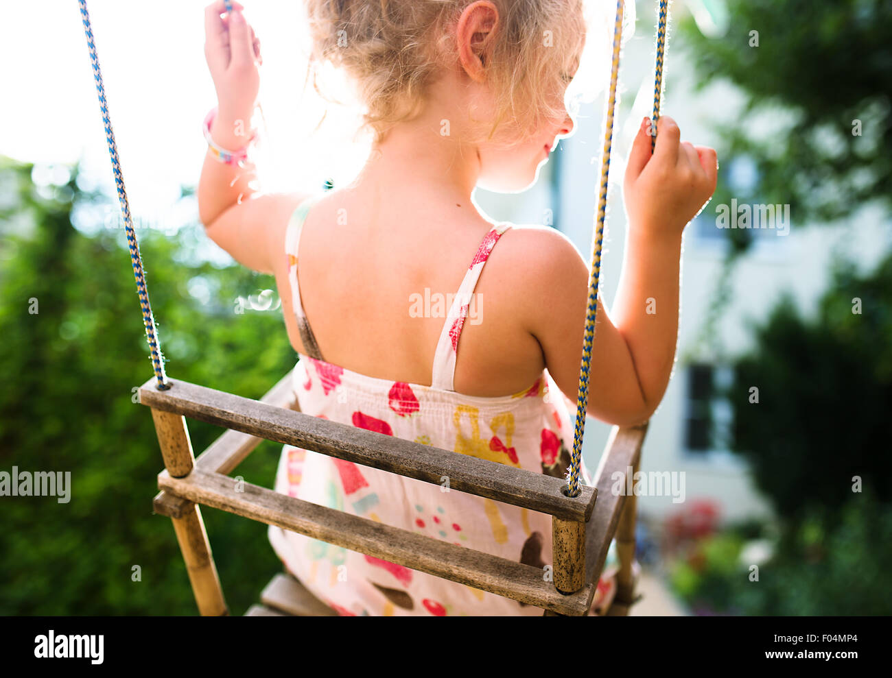 Glückliches Mädchen Spaß auf einer Schaukel an Sommertag Stockfoto