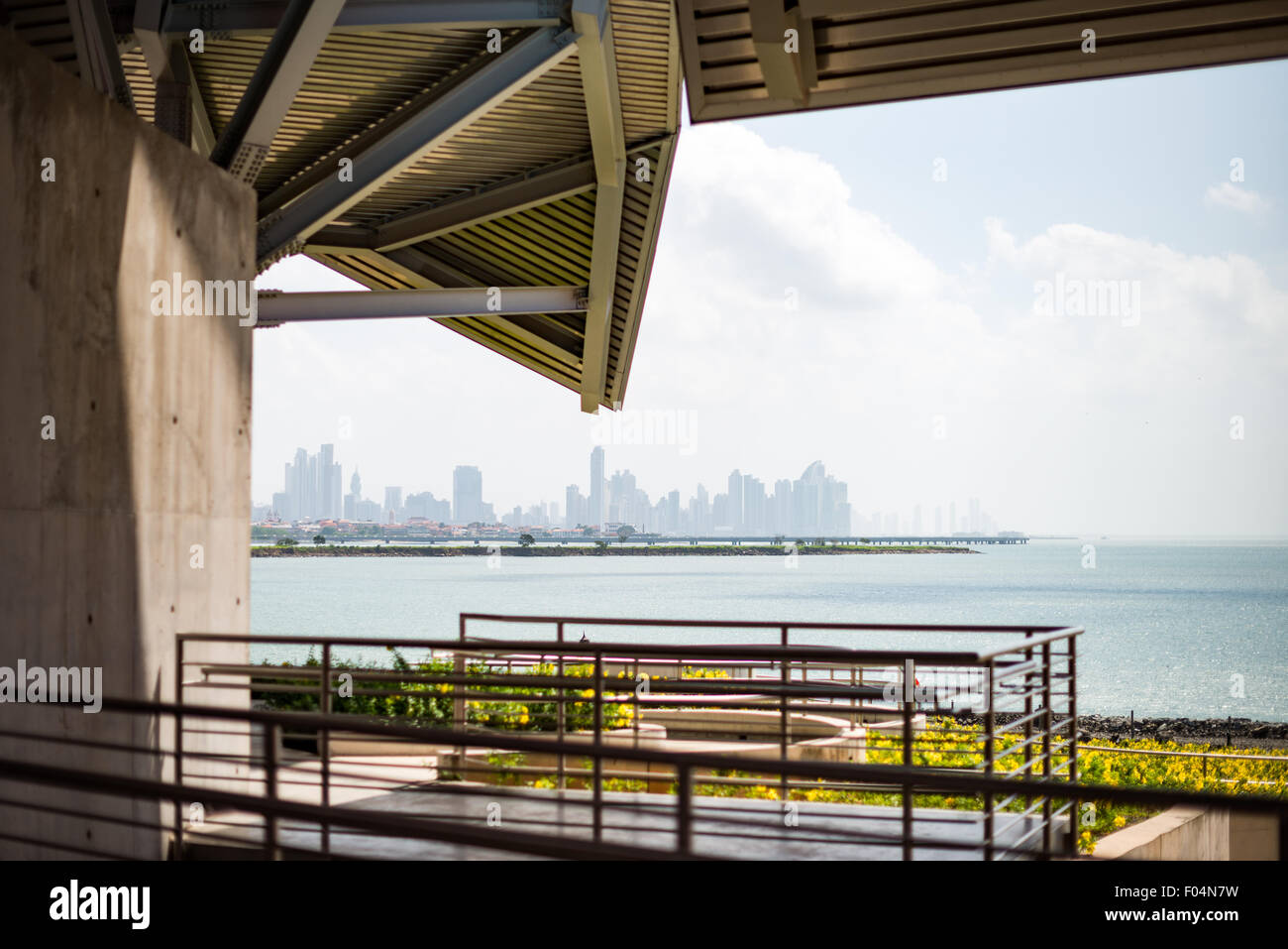 Panama City Skyline vom Biomuseo Panama // PANAMA CITY, Panama — Ein Panoramablick vom Biomuseo zeigt den Pazifik und die moderne Skyline von Panama City. Das Biomuseo wurde vom renommierten Architekten Frank Gehry entworfen und befindet sich am Eingang zum Panamakanal am Amador Causeway. Das Museum, das für seine farbenfrohen Dachpaneele bekannt ist, inspiriert von der Artenvielfalt des Landes, wurde 2014 eröffnet und konzentriert sich auf Panamas Natur- und Kulturgeschichte. Die in der Ferne sichtbare Skyline der Stadt zeigt die markanten Hochhäuser von Panamas Finanzviertel. Stockfoto