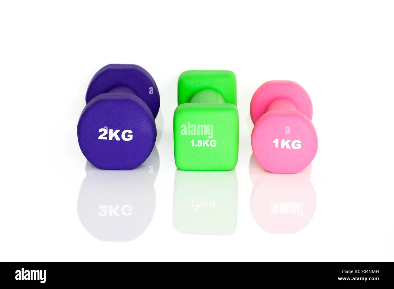 Lila, grün und rosa Fitness Hanteln isoliert auf weißem Hintergrund. Gewichte für ein Fitness-Studio-Training. Stockfoto