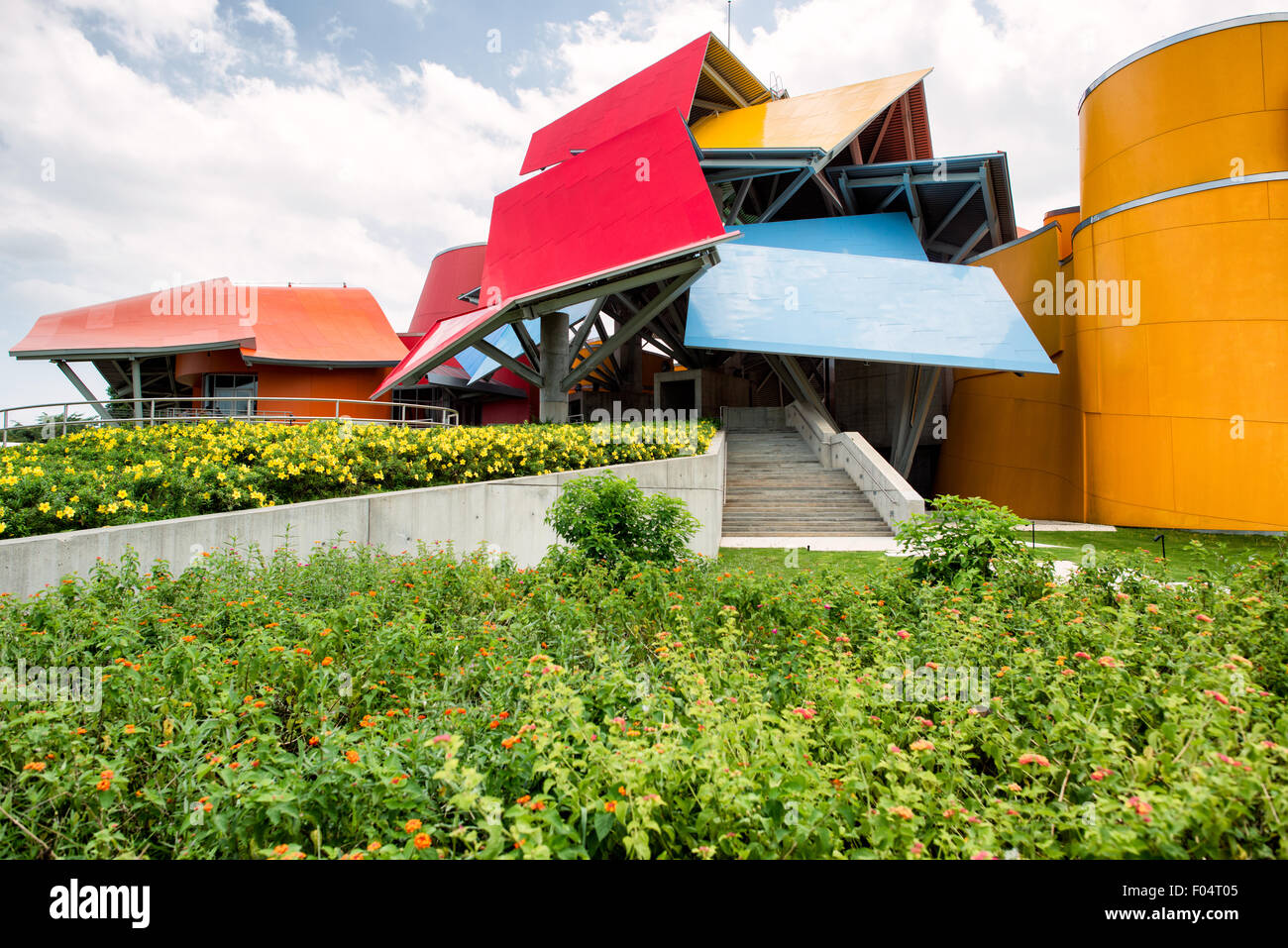 Biomuseo Frank Gehry Architektur Panama City // PANAMA CITY, Panama — das Biomuseo, entworfen vom renommierten Architekten Frank Gehry, steht an prominenter Stelle am Amador Causeway in Panama City. Das farbenfrohe, dekonstruktivistische Gebäude beherbergt ein naturhistorisches Museum, das sich mit Panamas Artenvielfalt und ökologischer Bedeutung befasst. Das Museum wurde 2014 nach fast einem Jahrzehnt Bauzeit fertiggestellt und verfügt über acht Ausstellungsgalerien, die Panamas Rolle als Landbrücke zwischen Nord- und Südamerika hervorheben. Das unverwechselbare Dach der Struktur, bestehend aus gefalteten Metallpaneelen in leuchtenden Farben, ist designet Stockfoto