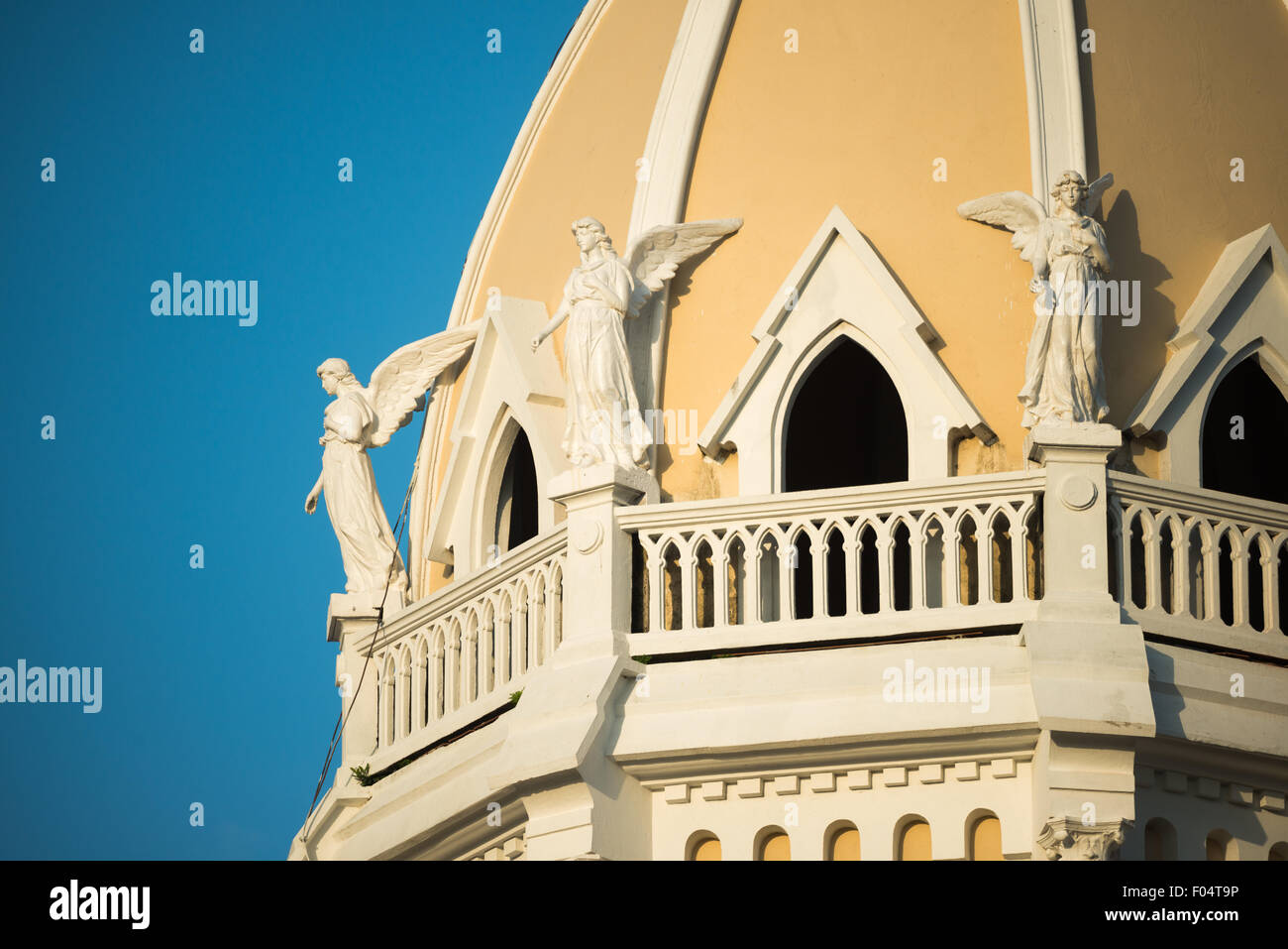 Iglesia San Francisco de Asis Engelstatuen Panama-STADT // PANAMA-STADT, Panama — Skulpturen von Engeln zieren den Turm der historischen Iglesia San Francisco de Asis im Stadtteil Casco Viejo von Panama City. Die Kirche aus der Kolonialzeit, die gegenüber der Plaza Bolivar liegt, wurde Mitte der 1700er Jahre zweimal durch einen Brand zerstört, bevor sie wieder aufgebaut wurde. Dieses architektonische Wahrzeichen befindet sich gegenüber dem Nationaltheater am Ufer und stellt einen wichtigen Teil des religiösen und kulturellen Erbes Panamas im von der UNESCO ausgewiesenen historischen Viertel dar. Stockfoto