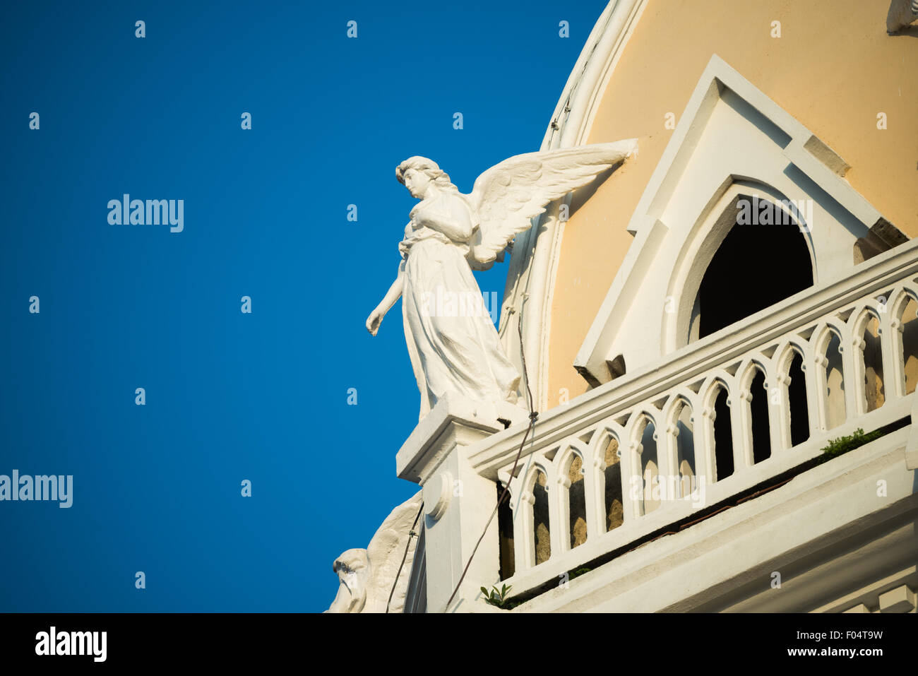 Iglesia San Francisco de Asis Engel Skulptur Panama-Stadt Panama // PANAMA-STADT, Panama — Skulpturen von Engeln zieren den Turm des historischen Iglesia San Francisco de Asis im Stadtteil Casco Viejo von Panama City. Die Kirche aus der Kolonialzeit, die gegenüber der Plaza Bolivar liegt, wurde Mitte der 1700er Jahre zweimal durch einen Brand zerstört, bevor sie wieder aufgebaut wurde. Dieses architektonische Wahrzeichen befindet sich gegenüber dem Nationaltheater am Ufer und stellt einen wichtigen Teil des religiösen und kulturellen Erbes Panamas im von der UNESCO ausgewiesenen historischen Viertel dar. Stockfoto