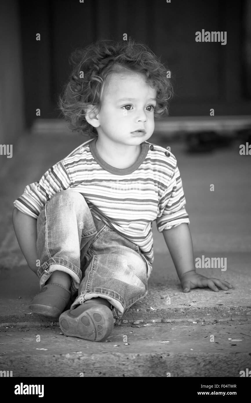 Porträt von 1 Jahre alten Jungen zu Fuß außerhalb des Hauses. Stockfoto