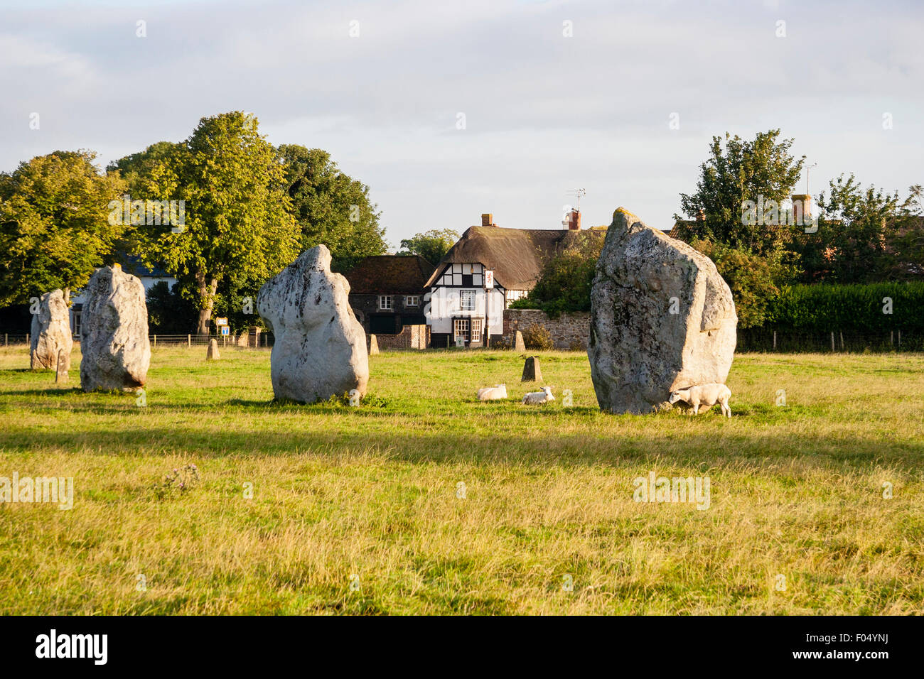 Neolithische Steinkreis von Avebury. Steine des Südlichen inneren Kreis, mit Hintergrund der Tudor Stil Bauernhaus und leichten blauen Himmel. Stockfoto
