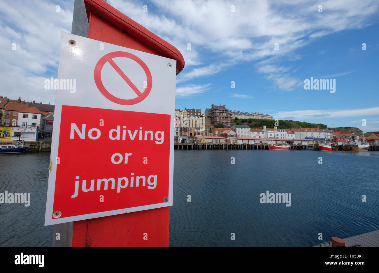 Schild Warnung über die Gefahren von Tauchen springen und Schwimmen an Whitby Hafen Kai Stockfoto