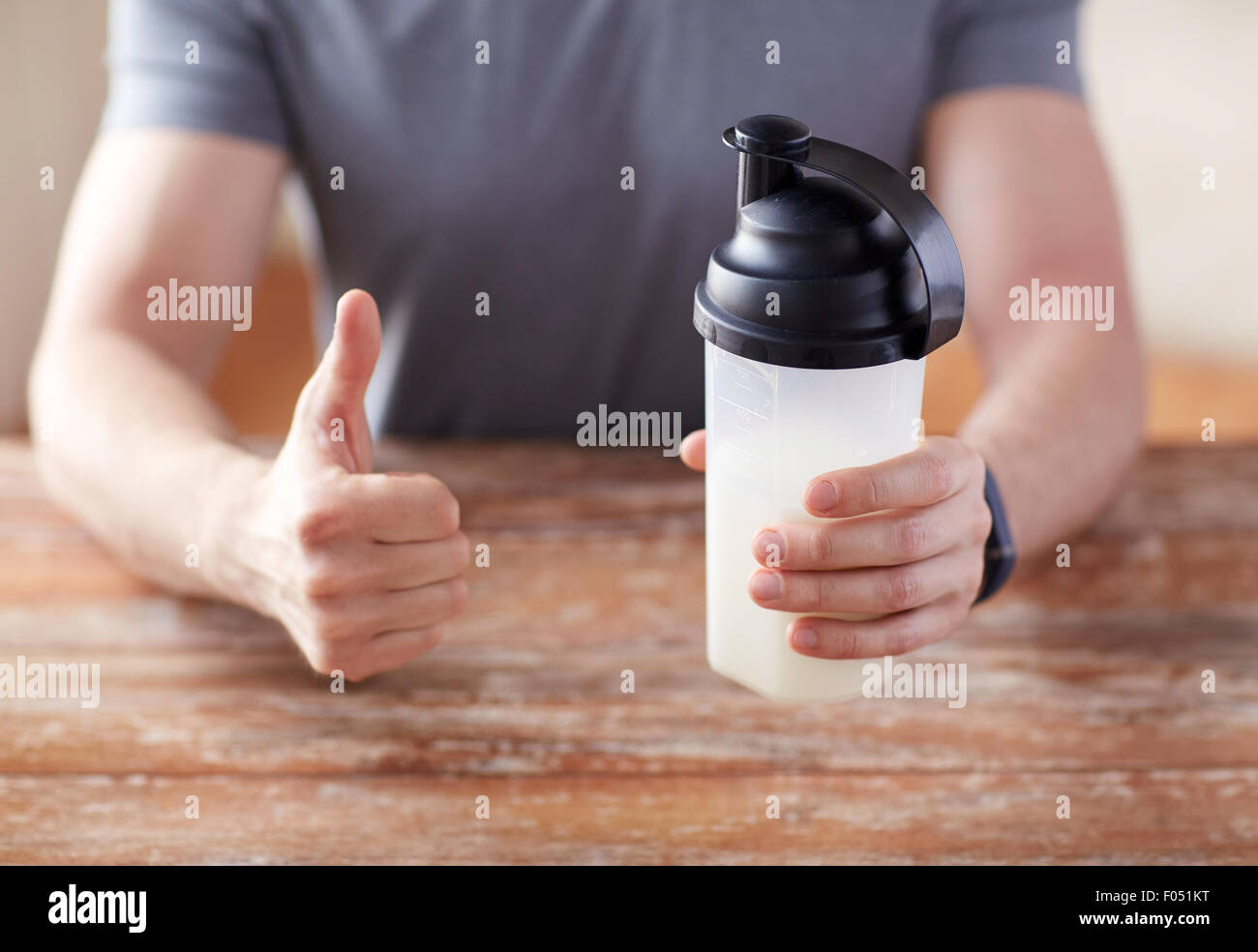 Mann mit Protein shake Flasche Daumen auftauchen Stockfoto
