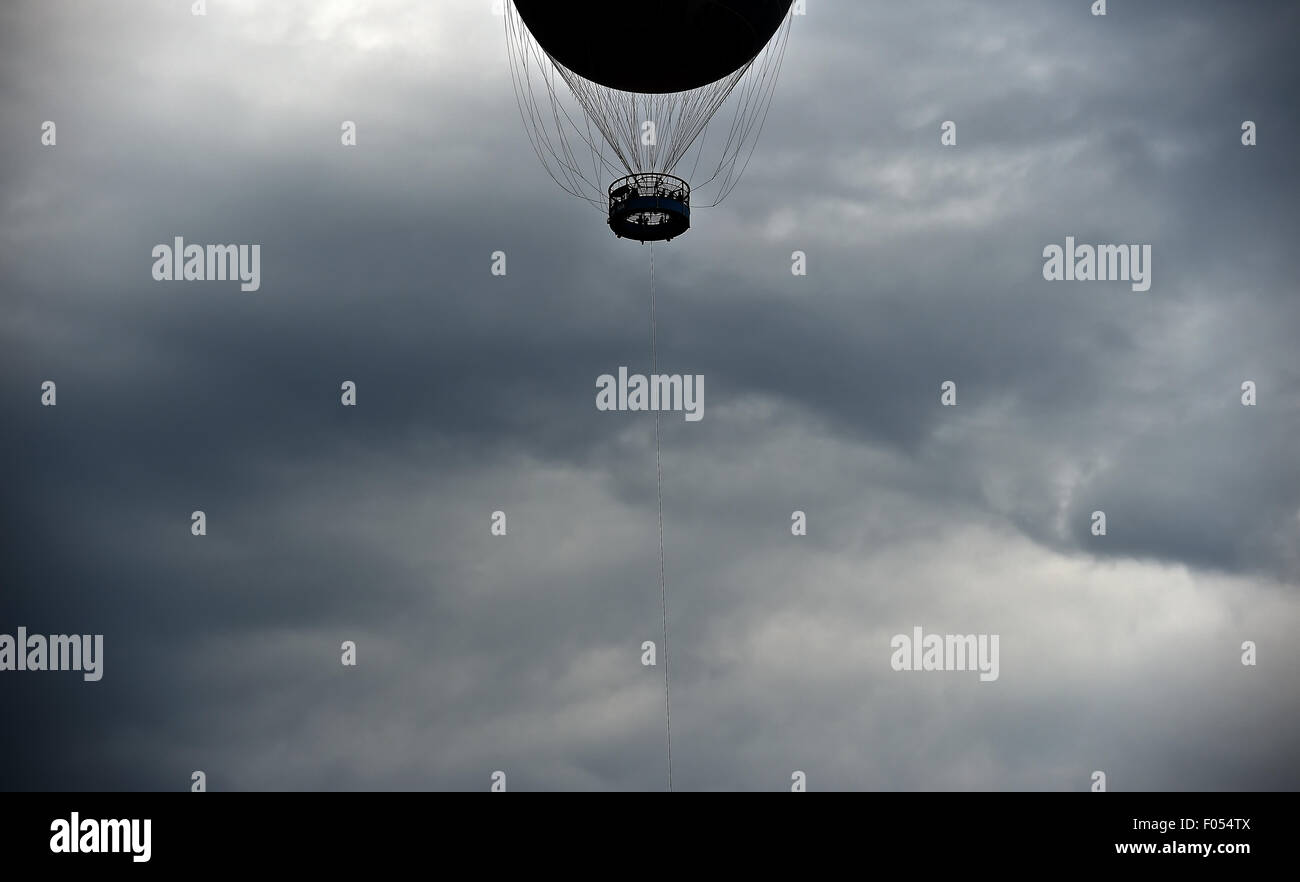 Berlin, Deutschland. 7. August 2015. Das Bild zeigt dunkle Wolken hinter einem Fesselballon in Berlin, Deutschland, 7. August 2015. Foto: Britta Pedersen/Dpa/Alamy Live News Stockfoto