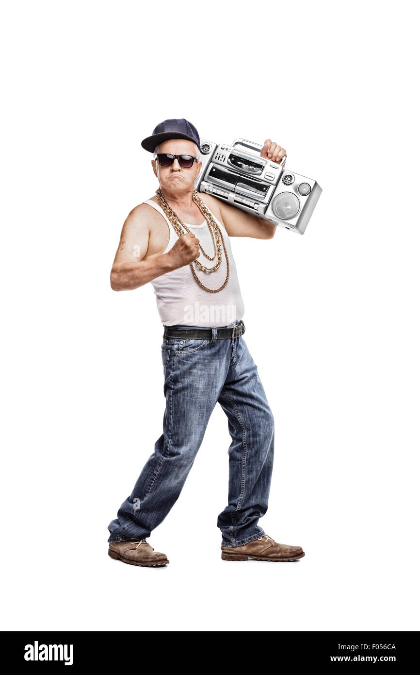 In voller Länge Portrait von einem reifen Mann in Hip-Hop-Outfit hält einen Ghetto-Blaster und schaut in die Kamera Stockfoto