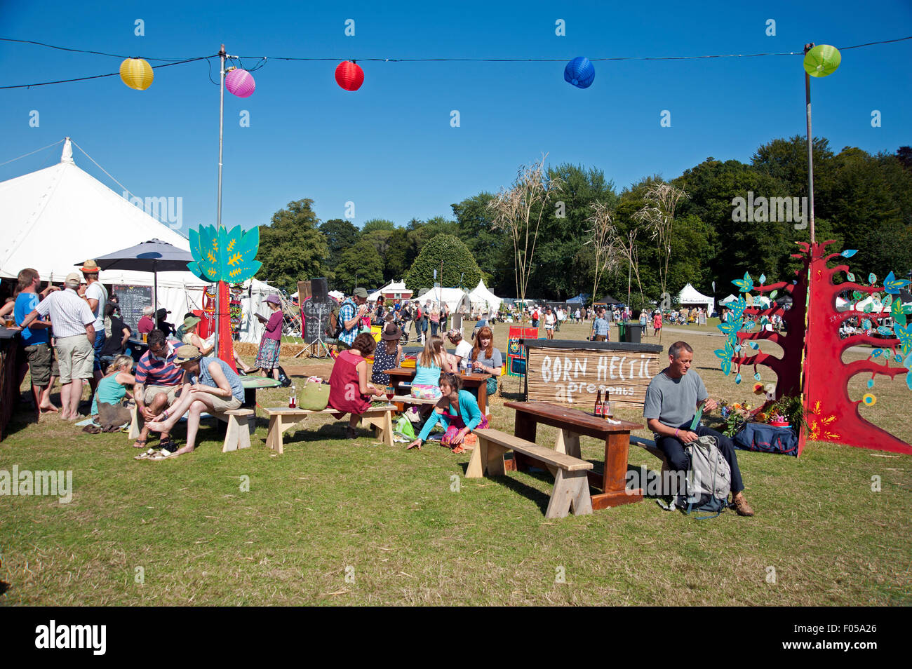 Familien-Partei in der Sommersonne von Garküchen und Zelten am Hafen Eliot Festival Cornwall Stockfoto