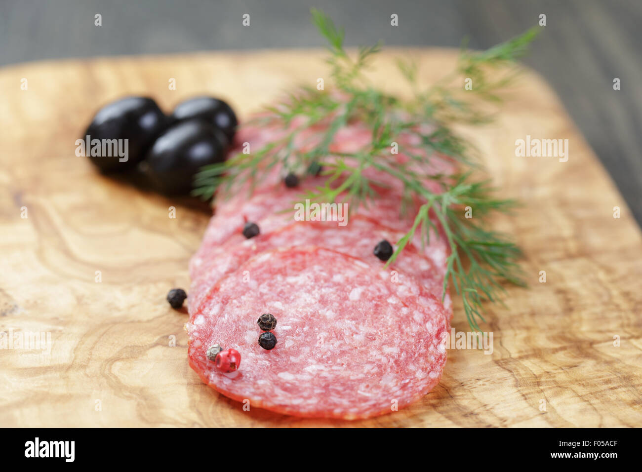 Salami mit Pfeffer auf Oliven Brett geschnitten Stockfoto