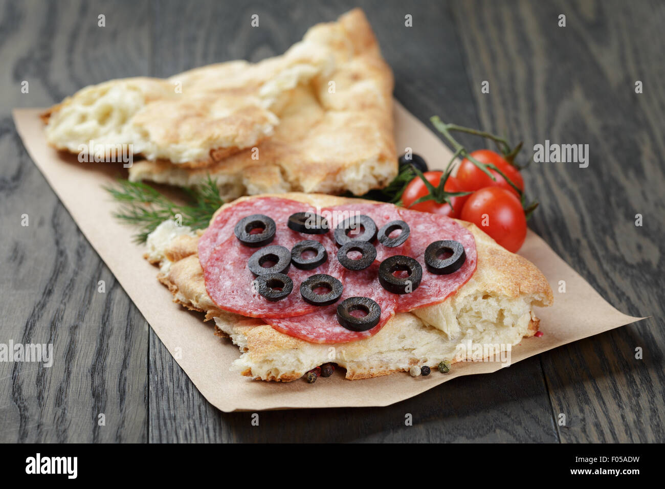 Sandwich mit Pita Brot Salami und Gemüse auf Tisch Stockfoto