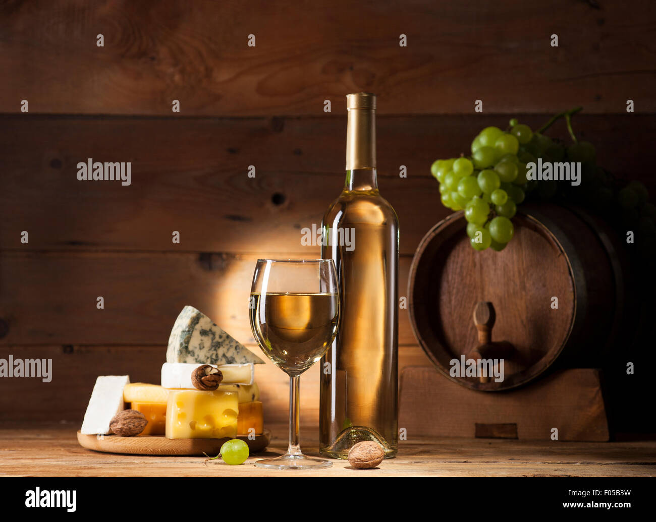 Weißwein mit verschiedenen Sorten Käse auf hölzernen Hintergrund Stockfoto