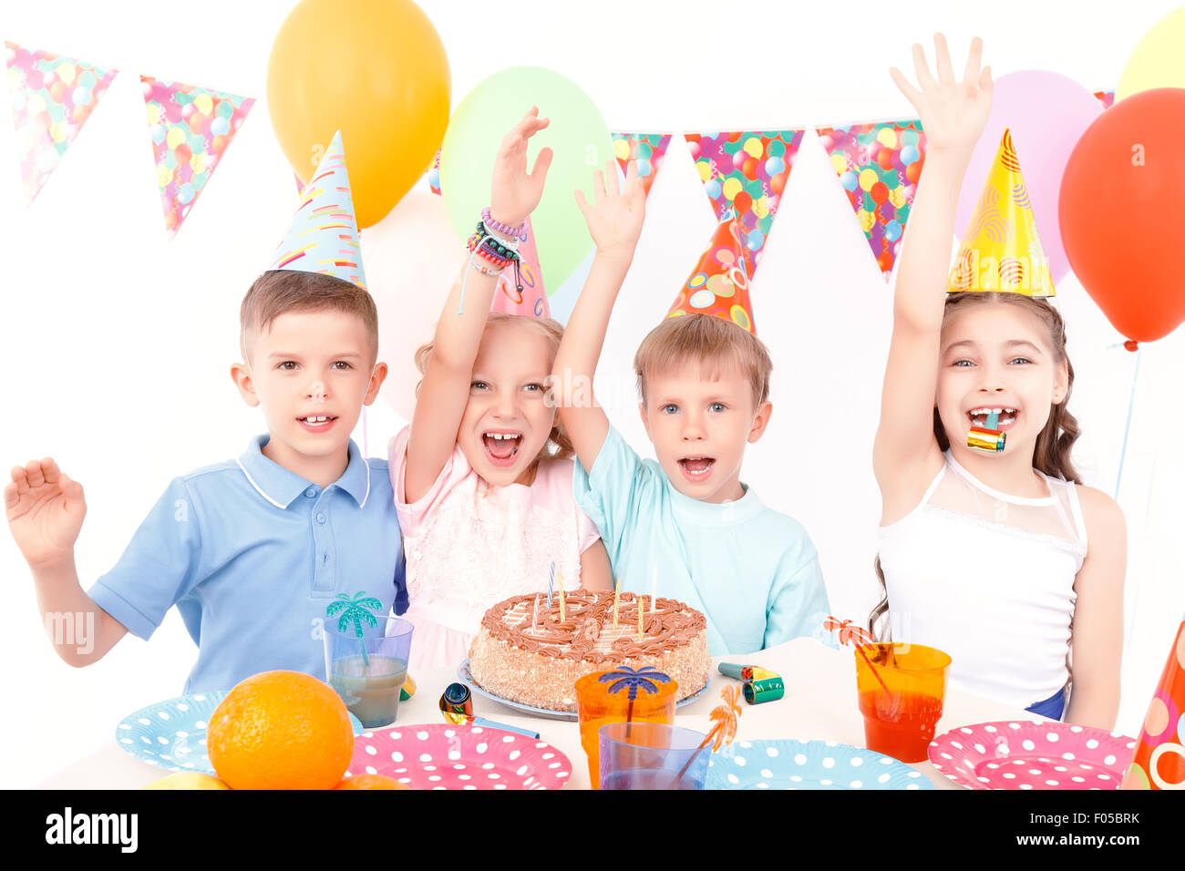 Glückliche Kinder posiert mit Geburtstagstorte Stockfoto