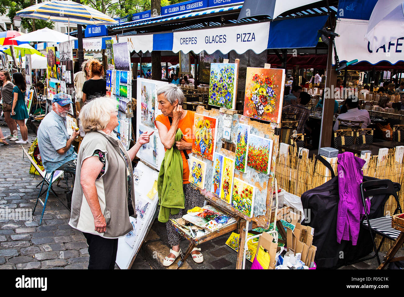 Im Montmartre Viertel von Paris verkaufen Künstler ihre ursprüngliche Kunst zu einer ewigen Masse der Touristen und Schaulustige. Stockfoto