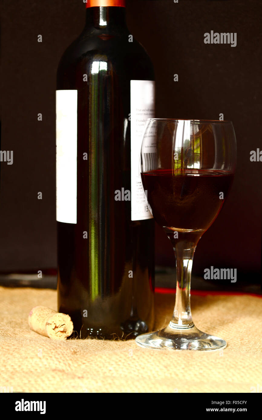 Flasche Rotwein und ein Glas Wein auf einer ländlichen Umgebung Stockfoto