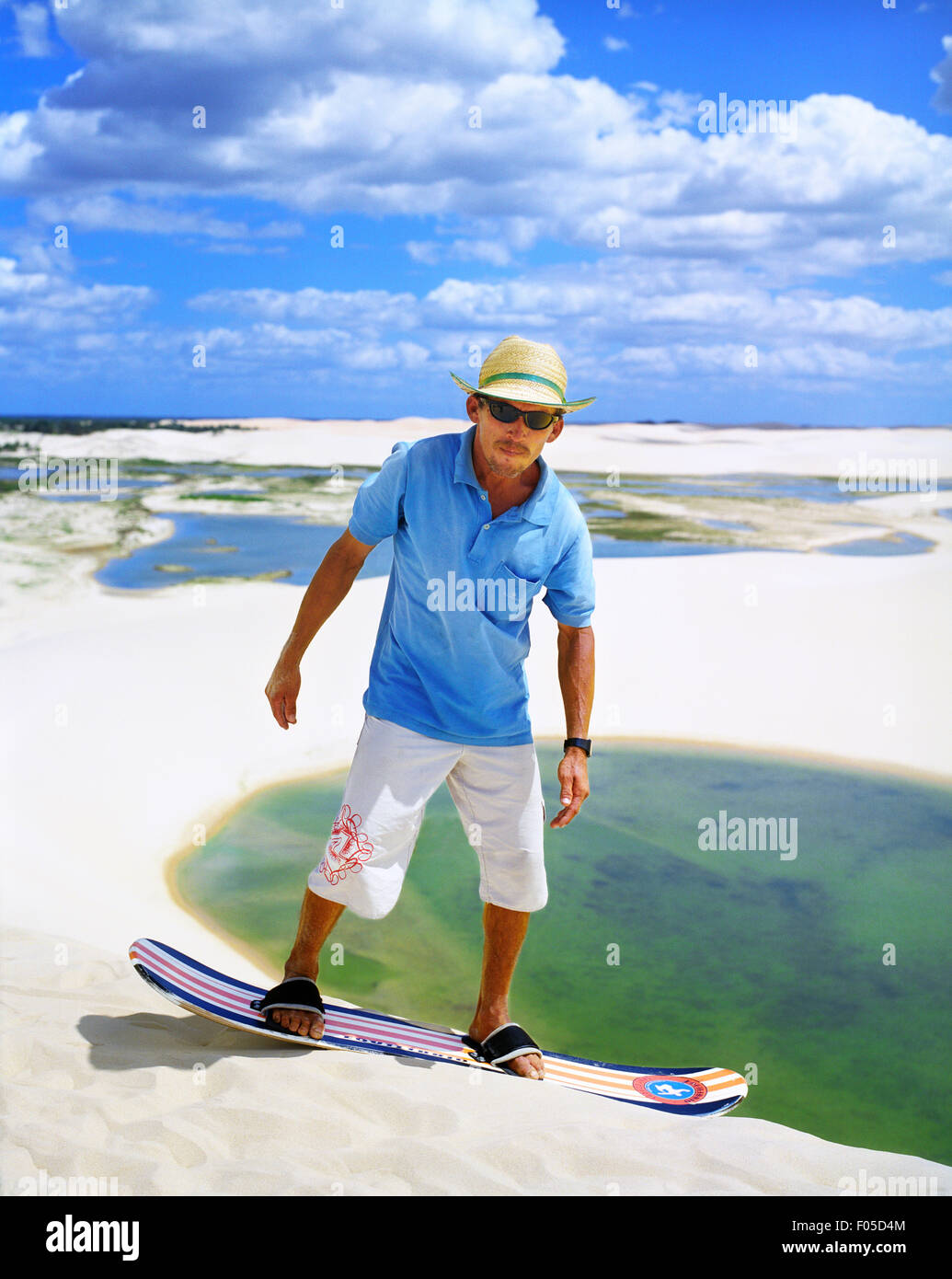 Ein brasilianischer Mann nimmt eine geführte Sand boarding auf einer Düne am Dunas Tatajuba, etwas außerhalb von Jericoacoara, Brasilien Stockfoto