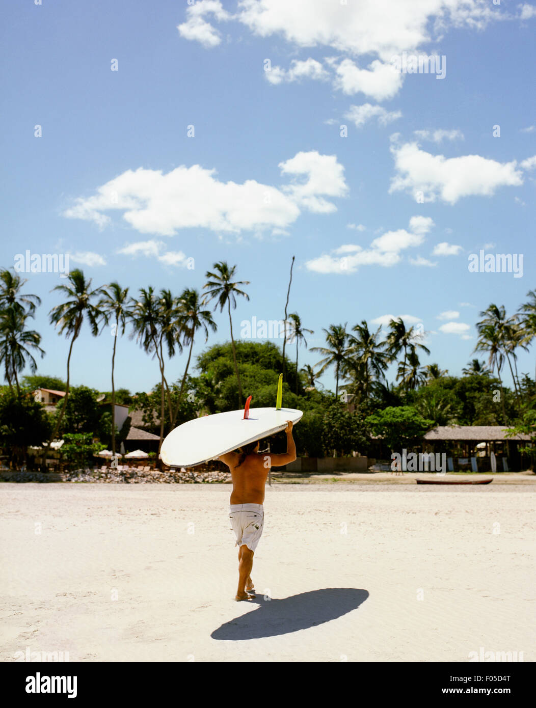 Ein Mann bringt seine Wind-Surf-Board aus dem Ozean. Jericoacoara, Brasilien. Stockfoto