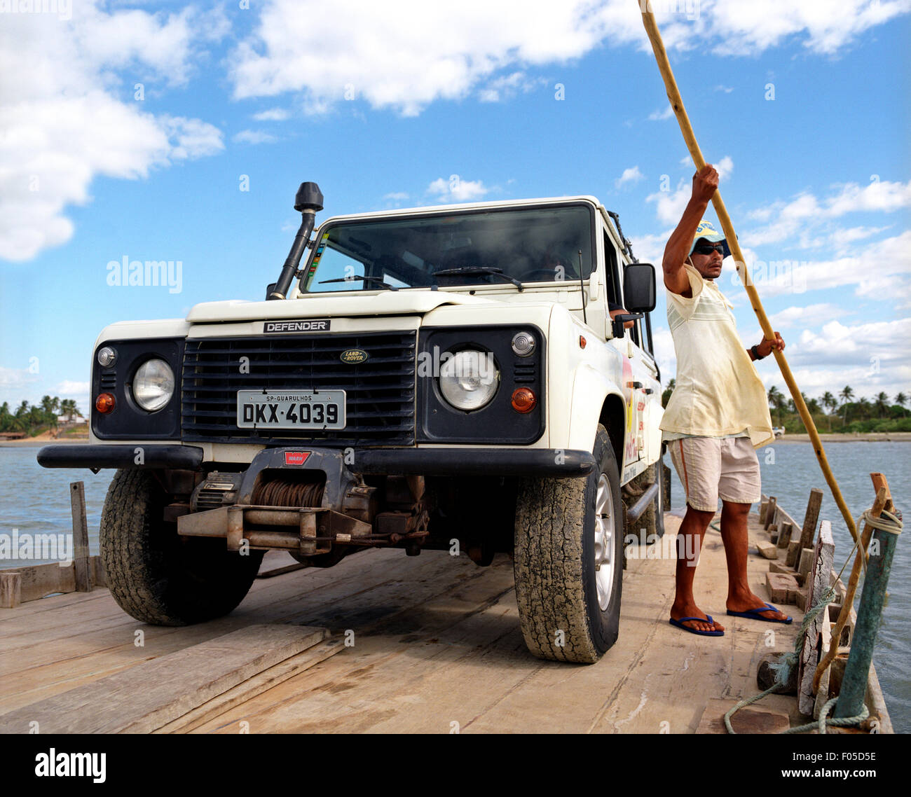 Ein Fähre-Betreiber bringt Land Rover durch einen Fluss in der Nähe von Jericoacoara, Brasilien Stockfoto