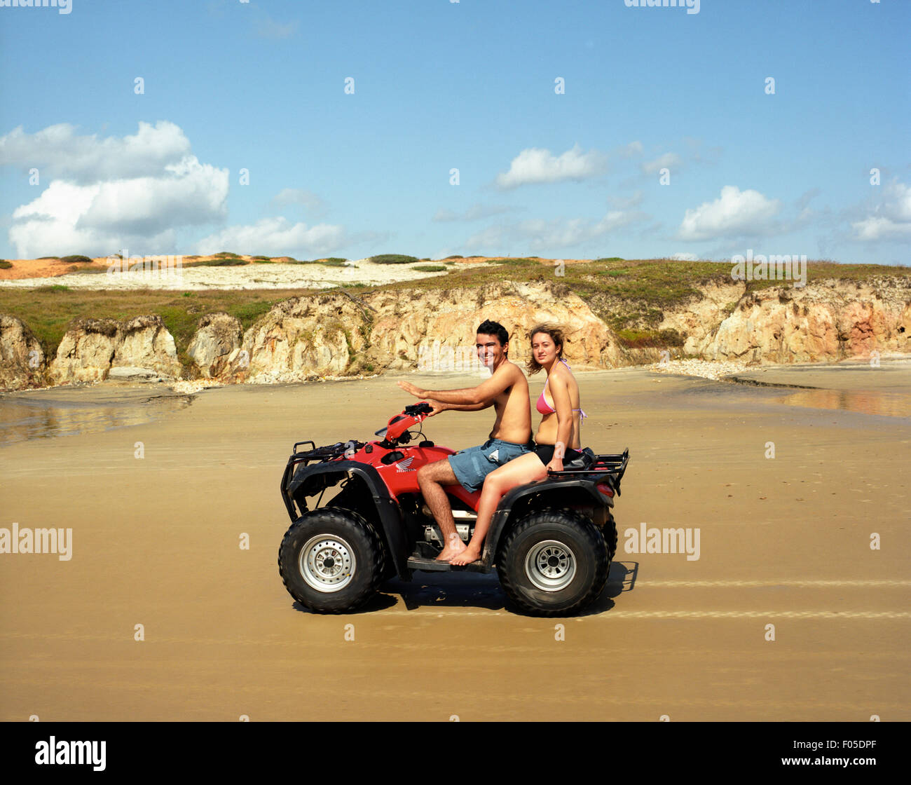 Ein junges Paar fahren einen Strandbuggy entlang des Strandes in der Nähe von Flexeiras, Brasilien. Stockfoto