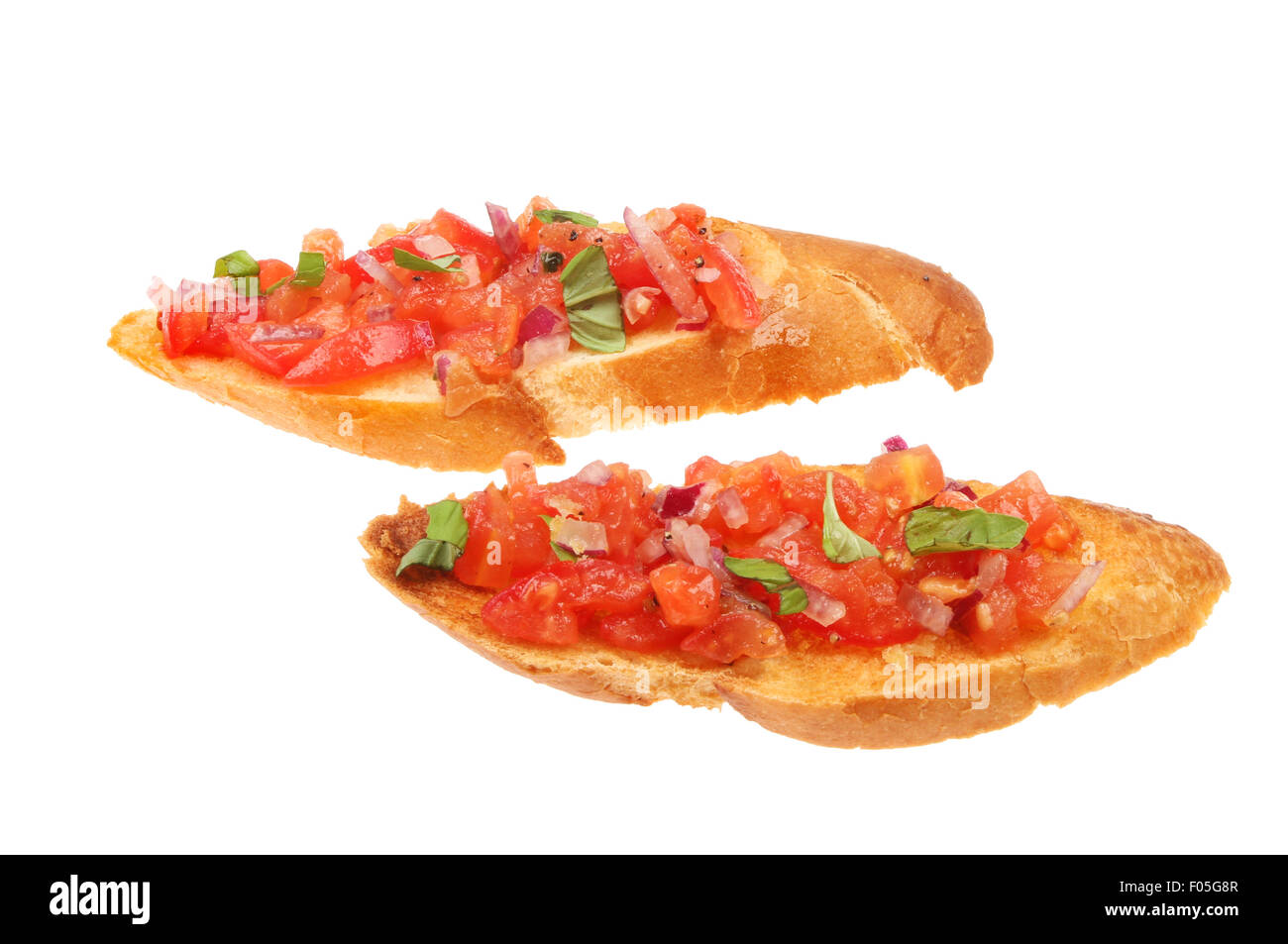 Zwei Scheiben Tomate, roten Zwiebeln und Basilikum Bruschetta isoliert gegen weiß Stockfoto