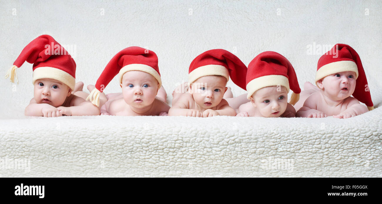 Babys mit Santa Hüte auf hellem Hintergrund Stockfoto