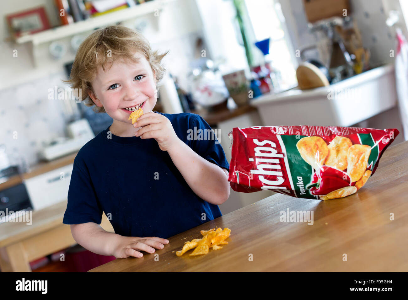 Junge, 4 Jahre, Chips essen Stockfoto
