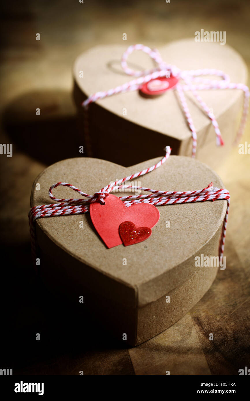 Geschenk-Boxen mit handgefertigten Herzen Stichwörter auf Holzbrett Stockfoto