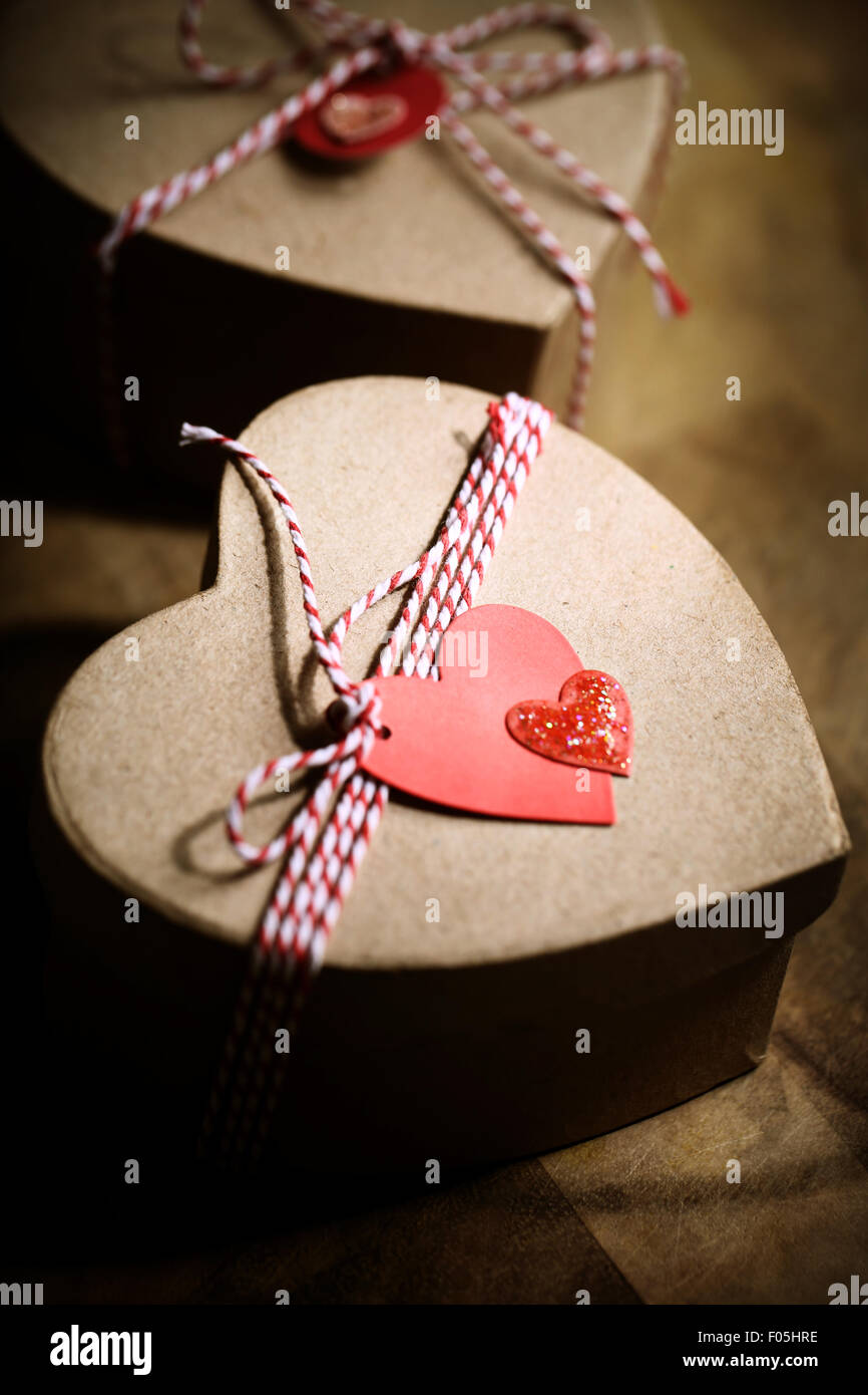 Geschenk-Boxen mit handgefertigten Herzen Stichwörter auf Holzbrett Stockfoto