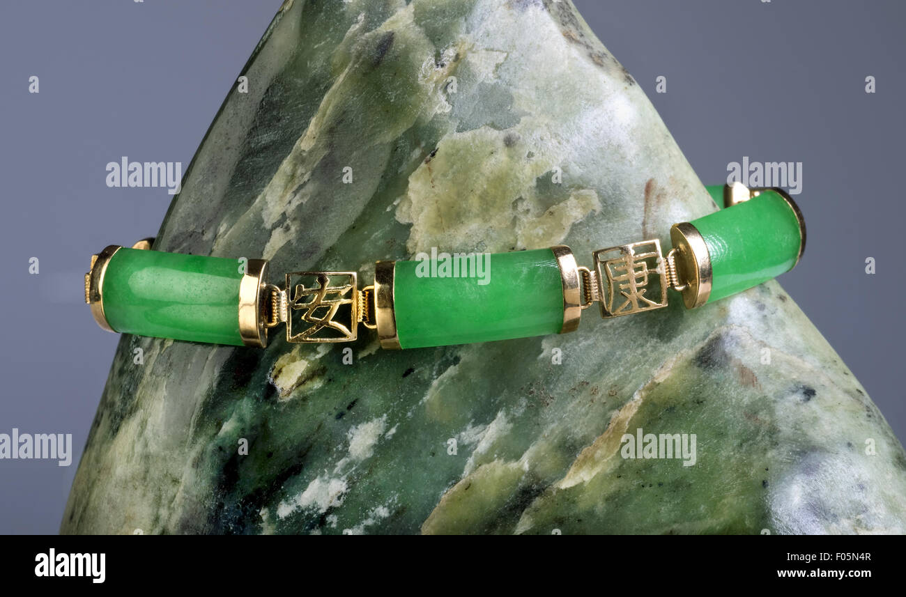 Kaiserliche grüne jade und gold Armreif auf jade Felsen. Stockfoto