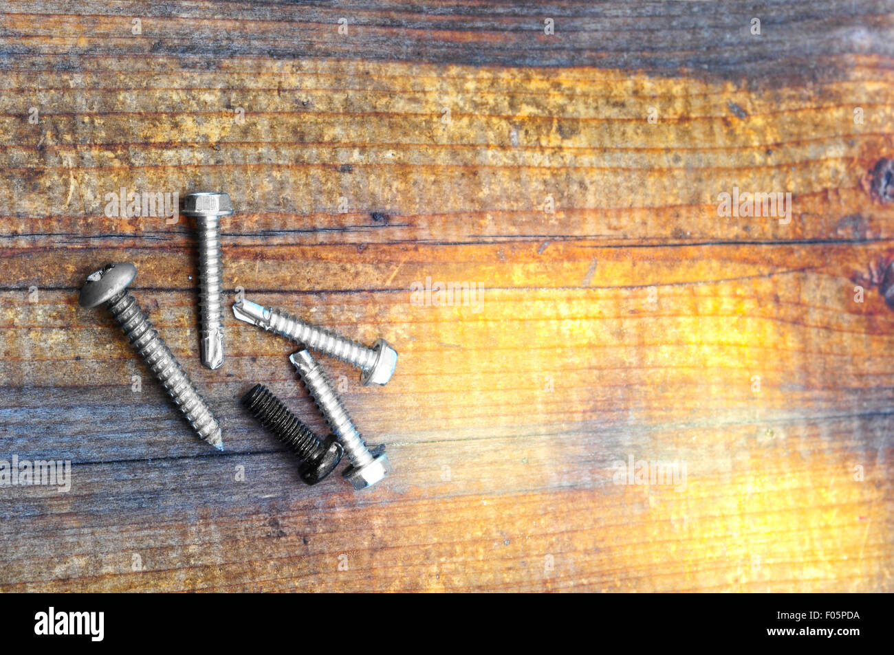 Makroaufnahme von mehreren Schrauben auf einem Holztisch Stockfoto