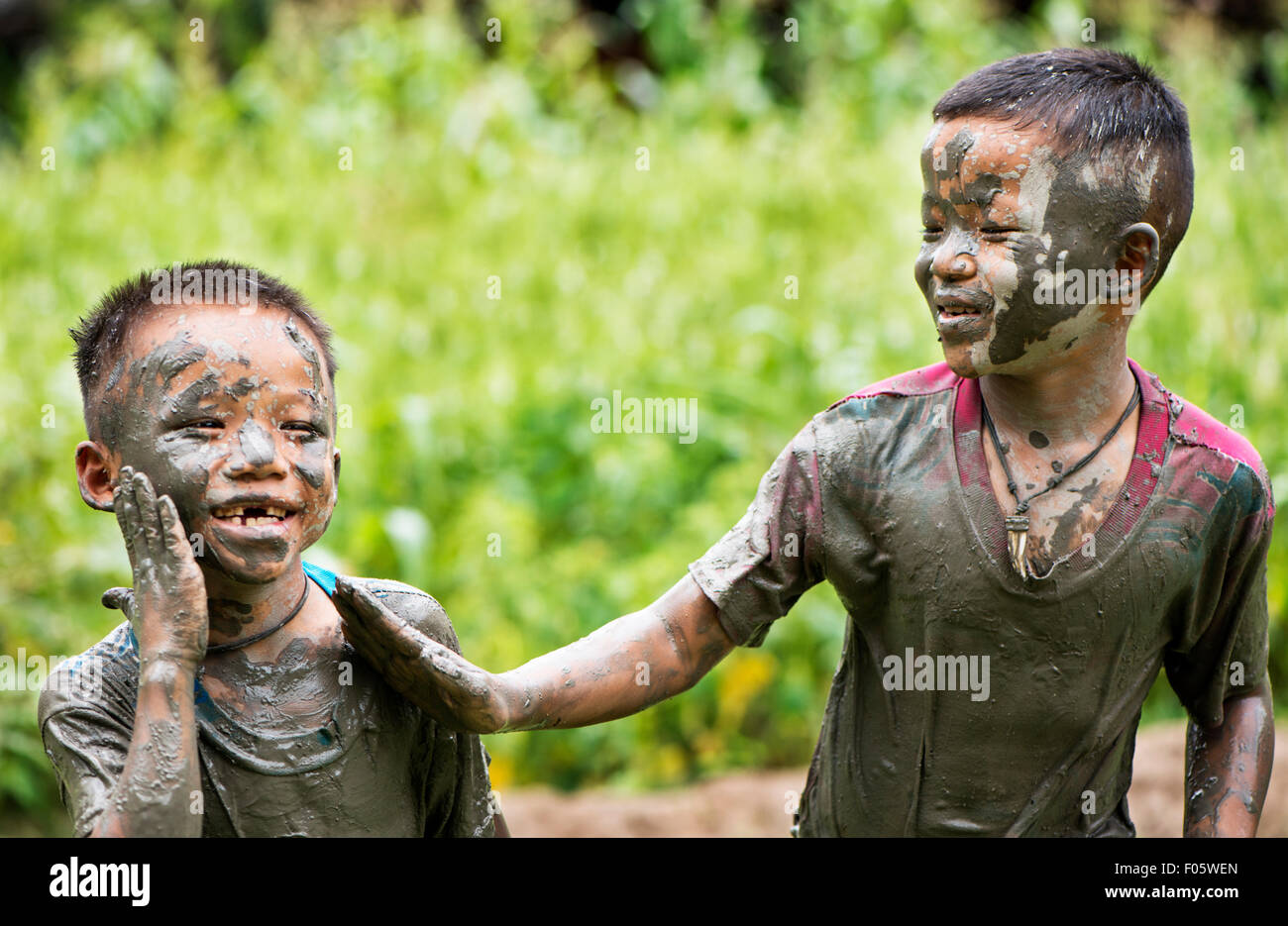 Hill Tribe Jungs spielen in den Schlamm in Chiang Mai, Thailand, Asien. Stockfoto